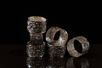 A stack of metal rings with an abstract pattern on a black background.