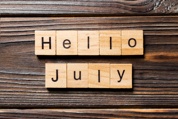 hello july word written on wood block. hello july text on table, concept - obrazy, fototapety, plakaty