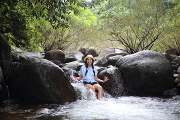 Woman soaking in the Trok Nong waterfall in Chanthaburi, Thailand