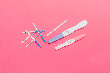 Colored Pregnancy test on colored background, top view with copy space