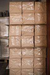 Printing products are wrapped in kraft paper and wrapped with scotch tape. Packs of paper lie on each other in the printing industry