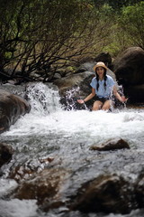 Woman soaking in the Trok Nong waterfall in Chanthaburi, Thailand