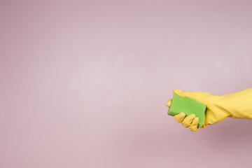 a gloved hand holds a sponge for disinfection. the concept of disinfection and sanitation in the...