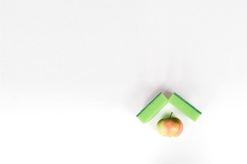 Naklejka premium Apple is framed with washing sponges. the concept of disinfection to protect yourself and your family, disinfection , purification, vulnerability