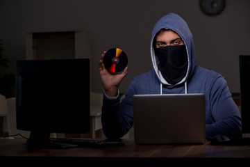 Male hacker hacking security firewall late in office