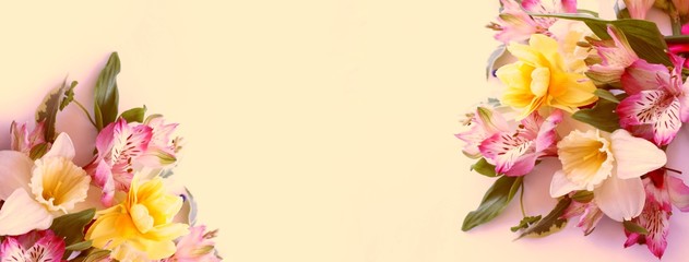 Spring flower arrangement. Pink Alstroemeria and yellow tulips on a light yellow background....