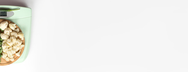 green beans, cauliflower blooms on a wooden tray on the scales. healthy, dietary food. balanced diet