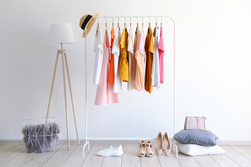 fashionable clothes on a rack in the interior of a bright room
