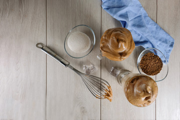Two glass cups with Dalgona foamy coffee trend Korean latte espresso drink with coffee foam on a light background. Copy space