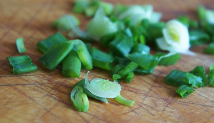 on a wooden chopping Board close up chopped green onions