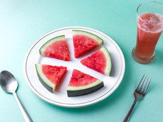 Sliced Watermelon on white plate with spoon and fork stock photo with white background.