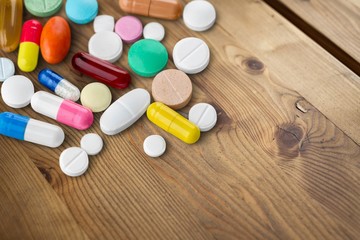 Colorful round pills and capsules on the desk