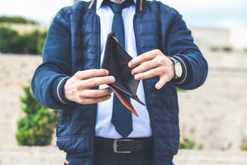 man shows an empty brown wallet