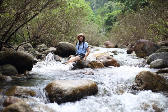 Woman soaking in the Trok Nong waterfall in Chanthaburi, Thailand