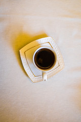 Top view of fresh and aromatic hot black coffee in white ceramic cup for cheerful morning or break time