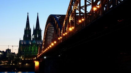 Obraz premium Kölner Dom und Hohenzollernbrücke im Sonnenuntergang am Abend
