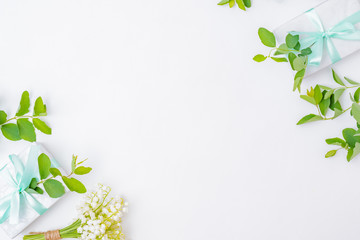 Flat lay festive composition with white flowers and a gift box on a white background