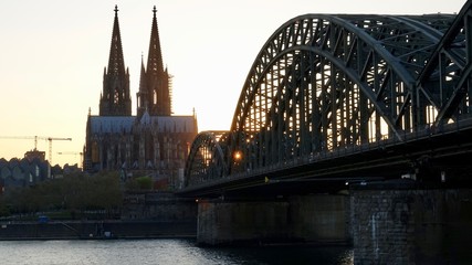 Fototapeta premium Kölner Dom und Hohenzollernbrücke im Sonnenuntergang am Abend