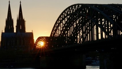 Fototapeta premium Kölner Dom und Hohenzollernbrücke im Sonnenuntergang am Abend