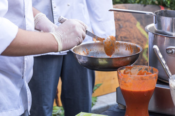 Chef preparing pasta boiling pasta and cooking. Food catering live cooking station during reception
