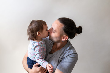 Father kiss his lovely and cute little daughter on white background. Father's Day conception
