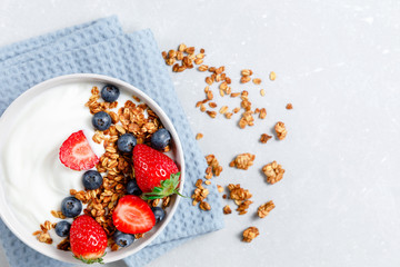 Homemade oatmeal granola bowl with greek yogurt, berries, honey and nut