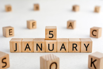 January 5 - from wooden blocks with letters, important date concept, white background random letters around