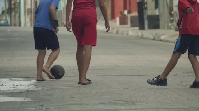 Children Training Playing Football Barefoot In Ghetto, Cuba. Footbal game around the world concept. The Republic of Cuba, urban scene. Football and soccer in Cuba