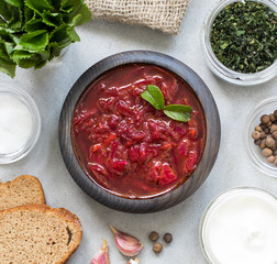 Beetroot soup in a wooden bowl on a light background top view