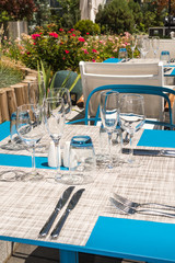 Table setting outdoor terrace. Nobody in the picture just table setup with cutlery and glasses.