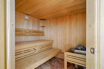 Traditional Finnish bath - sauna. Sauna wooden room with wooden benches and a stone stove