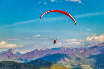 Flying paraglider from the Stranik hill over the mountainous landscape of the Zilina basin in the...