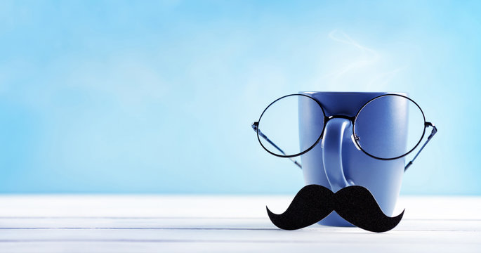 Creative breakfast on Happy Fathers Day with funny face from cup of coffee, eyeglasses and mustache. Greeting card for daddy.