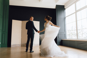 The bride and groom, European appearance. Rehearse the first wedding dance, or dance and whirl, holding hands. Wedding couple. Full-length photo.