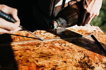 male artisan processes an array of wood with epoxy varnish. renovation of antique furniture.
