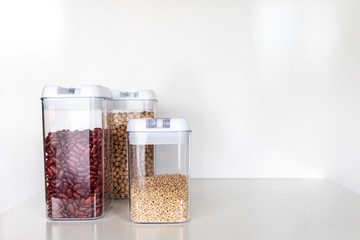 Three Clear Pantry Containers Filled with Non-Perishable Foods-- Dried Beans and Grains