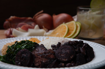 Feijoada com ingredientes ao fundo