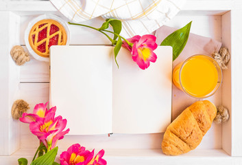 Rustic breakfast with pink flowers, orange juice, croissant, dessert on white wooden tray. Place for text. Space for text. Romantic mood, planner. FLatlay. Culinary background. Recipe book