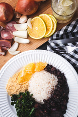 Feijoada com ingredientes ao fundo