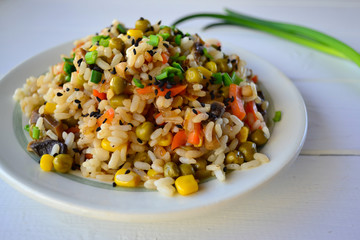 Steamed rice with mixed vegetables and green new onion on a white background.