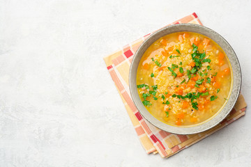Lentil soup with vegetables in bowl on concrete background