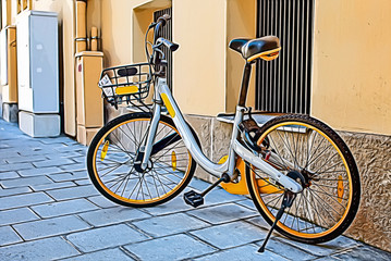 A bicycle parked in a street on sunny day in a city.