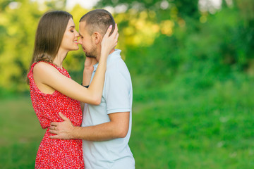 guy and girl kissing each other on the green meadow