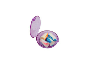 Isolated colorful silicone earplugs in the open protective plastic case on a white background....