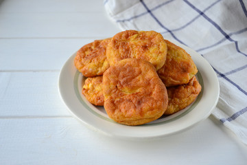 Sweet cottage cheese pancakes baked with no oil, on a white plate with a horizontal orientation.