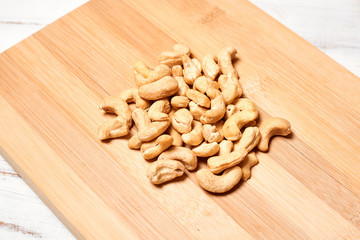 Raw cashew nuts close-up on a light wooden background.