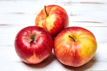 Ripe red apples on a wooden background.