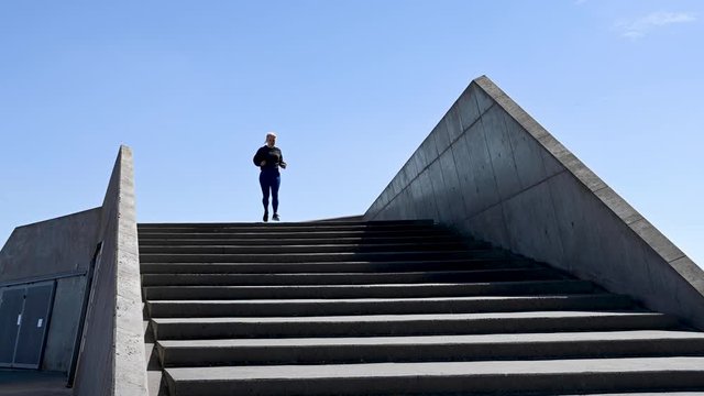Attractive young woman, running down stairs in real time, stock footage by Brian Holm Nielsen