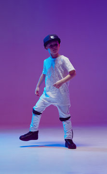 Cool young boy child dancing hip hop in the Studio against the background of neon lights. Break dance poster.