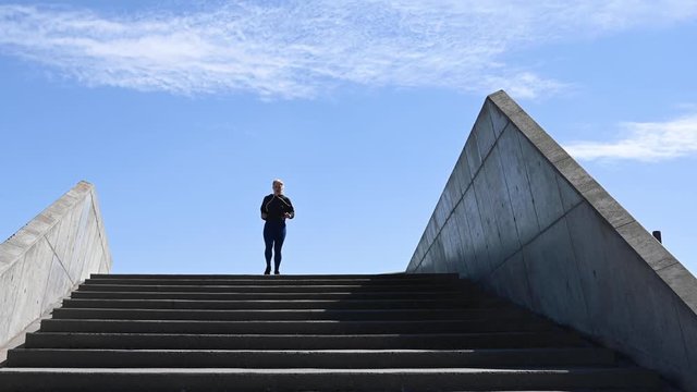 Attractive young woman, running down stairs in real time, stock footage by Brian Holm Nielsen